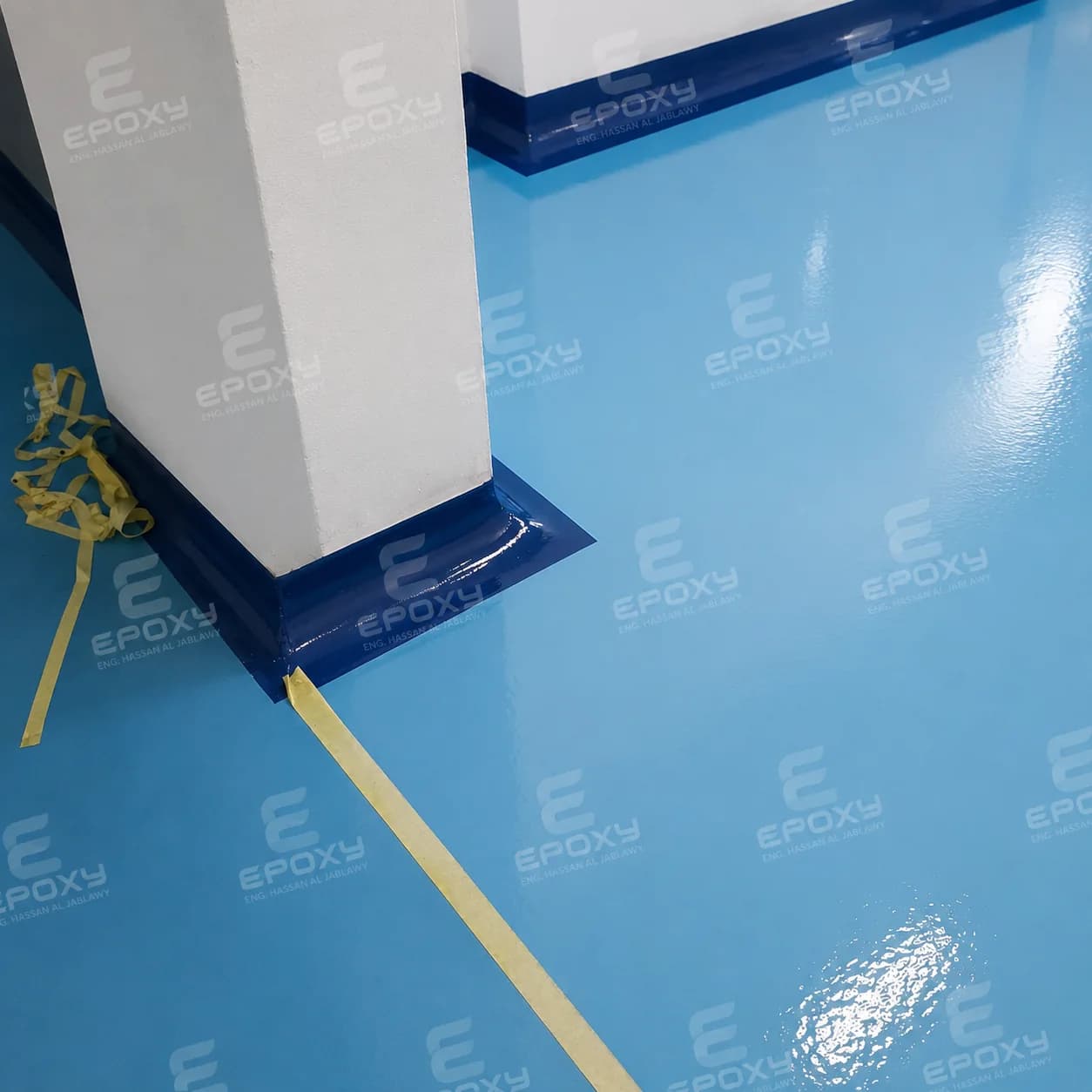 Blue epoxy floor with yellow linework inside a factory